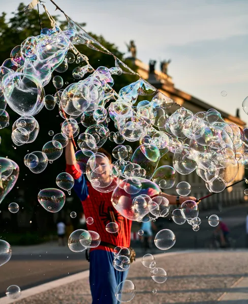 Street performer in Spider-Man costume surrounded by iridescent soap bubbles